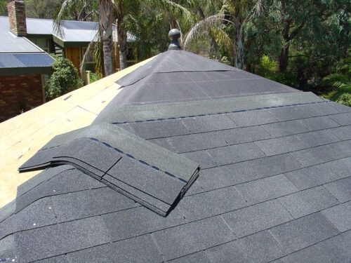 Shows how light and manageable the shingles are Person carrying lightweight roofing materials